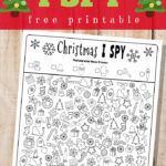 Christmas I spy worksheet on wooden background with red and green text overlay