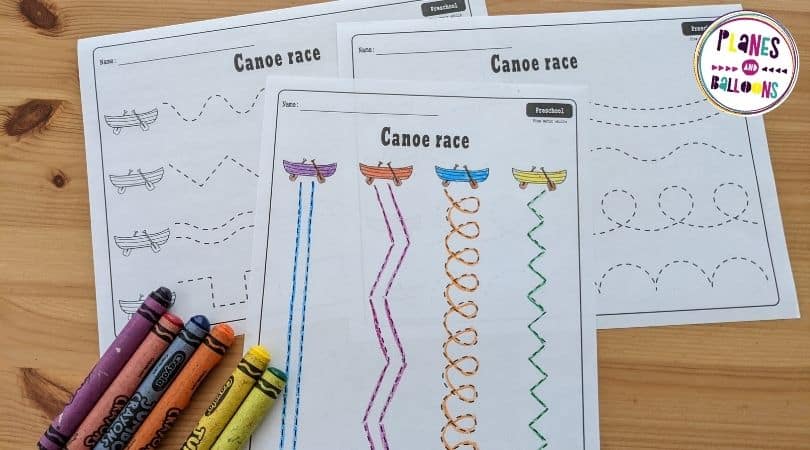 Canoe tracing lines worksheets on wooden table with crayons