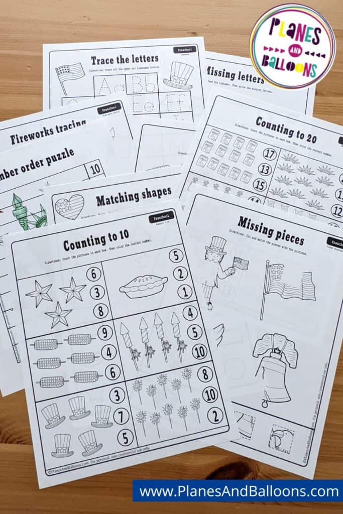 10 worksheets spread out on wooden table with Planes&Balloons watermark