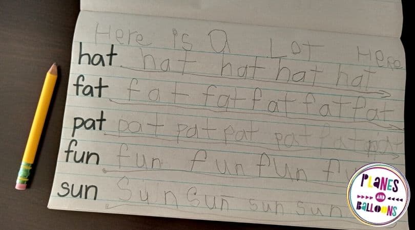 Writing journal for kindergarten practice on black table with a pencil