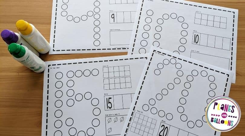 Dot marker number worksheets on wooden background with markers 