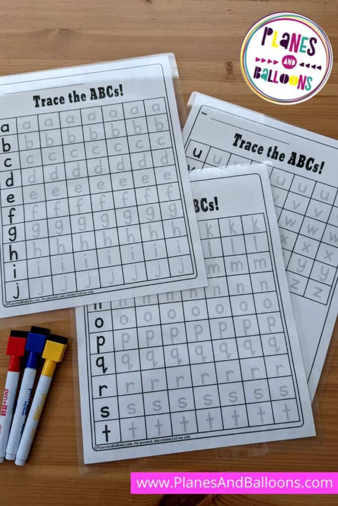 The tracing capital and small letters worksheets on wooden table with dry-erase markers
