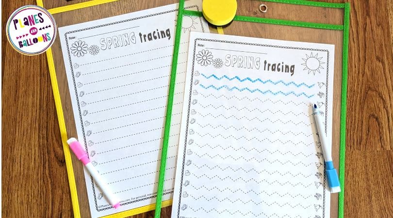 Spring tracing lines worksheets in sheet protectors on wooden background